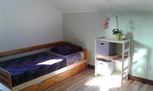圣若瑟Kaznanou的一间卧室配有一张床和一个床头柜