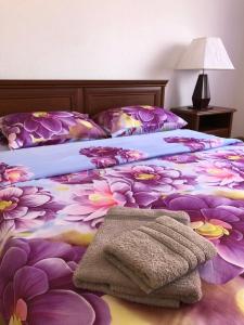 Novyye PetrovtsyGuest house on Ivana Franka的一间卧室,床上有紫色鲜花