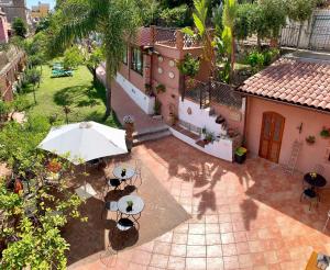 贾迪尼-纳克索斯B&B Villa Vittoria的享有房子的空中景色,配有雨伞和桌子