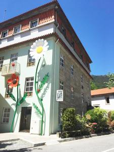 吉尔斯Hotel Central Jardim的一座建筑物,两旁有花朵被漆成