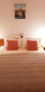科尔丘拉Villa Jade Apartments FRONT ROW SEA VIEW - WALK TO KORCULA OLD TOWN的一间卧室配有红色枕头的床