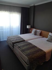 恩特龙卡门图霍奥多姆酒店的配有窗户的酒店客房内的两张床