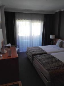 恩特龙卡门图霍奥多姆酒店的酒店客房设有两张床、一张书桌和一个窗户。