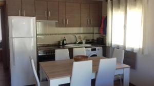 卡马雷纳德拉谢拉Apartamento Las Eras的厨房配有桌子和白色冰箱。