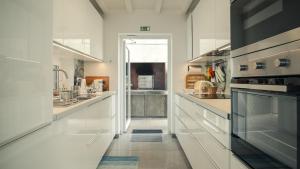 波尔图镇Villa Natura的白色的大厨房配有白色的柜台和电器
