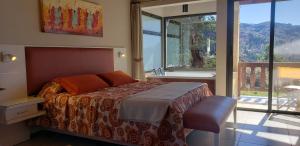 坎伯雷塔Aires Serranos - Suites的一间卧室设有一张床、一个窗口和一个浴缸