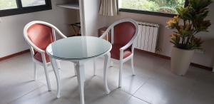 坎伯雷塔Aires Serranos - Suites的玻璃桌和两把椅子
