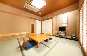 成田若松本酒店的客厅配有木桌和椅子