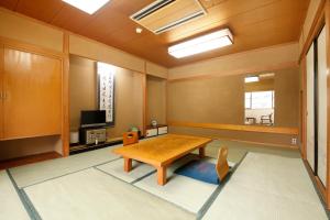 成田若松本酒店的一间带桌子和电视的用餐室