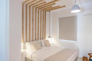 卡马利乔安娜别墅酒店的卧室配有白色的床和木制床头板