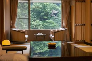神户有马温泉月光园鸿胧馆的客房设有桌子和大窗户。