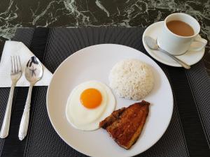 第波罗B&S Orchids suites hotel的鸡蛋,米饭,咖啡的盘子