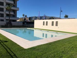 多列毛利诺斯Suite Home Los Alamos sol, playa y golf , parking&Wifi的一座游泳池,位于一座建筑旁的院子内