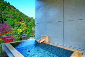 神户有马温泉月光园鸿胧馆的享有森林美景的按摩浴缸