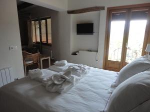 GuiametsHotel Rural Cal Torner Adults Only的卧室配有白色床和毛巾