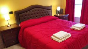 罗马Casa Vacanza Katiuscia的一间卧室配有红色的床和2条毛巾