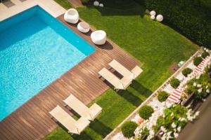 思科纳Apartmenthotel Ritterhof Suites & Breakfast的享有带躺椅和躺椅的游泳池的顶部景致