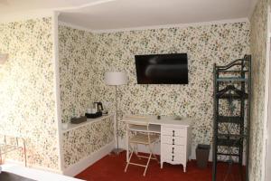 克勒兹河畔阿尔让通Manoir de Boisvillers的一间房间,配有一张桌子和一台墙上的电视