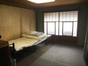FukiGuesthouse Fuki Juku的小房间设有床和2个窗户