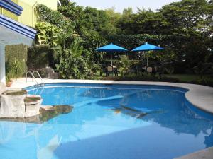 卡特马科普拉亚克里斯托尔酒店的一个带蓝色水和两把遮阳伞的游泳池
