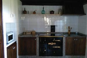里瓦德奥A Minguxaina的厨房配有黑炉和微波炉