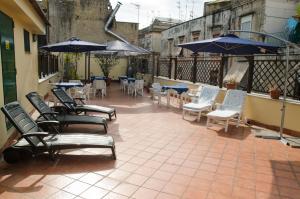 那不勒斯Backpacker Naples的一个带桌椅和遮阳伞的户外庭院。