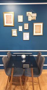 阿尔马达Afonso Galo Guest Apartments I的一张桌子、椅子和一张蓝色的墙壁,墙上挂着照片