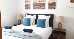阿尔马达Afonso Galo Guest Apartments I的一间卧室配有一张带蓝色和白色枕头的床