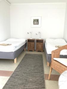 BoarpHillesgården的一间卧室配有两张床、一张桌子和一张地毯。