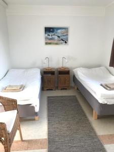BoarpHillesgården的配有2张床的带椅子和2张桌子的房间