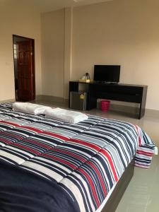 PrakhamPakham Gardens Resort的一间卧室配有一张大床和一张书桌