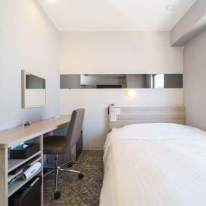 藤泽Super Hotel Shonan Fujisawaeki Minamiguchi的配有一张床和一张书桌的酒店客房