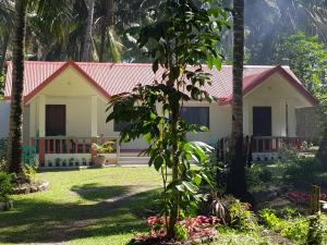 曼巴豪SJ Pabua Travellers Inn的一间白色的小房子,有红色的屋顶