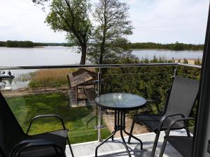 米科瓦伊基Apartamenty Zełwągi的阳台配有桌椅,享有湖景