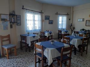 菲罗斯特法尼菲罗斯特法尼别墅酒店的一间设有蓝色桌椅和窗户的用餐室