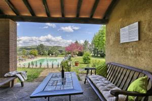 波马兰切Appartamento Spiga - Agriturismo Le Selvole的一个带桌子和长椅的庭院和一个游泳池