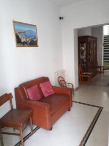 阿奇雷亚莱Casa delle Aci的客厅配有棕色沙发和桌子