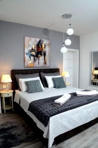 扎达尔Apartments La Luna的卧室配有一张大床,墙上挂有绘画作品