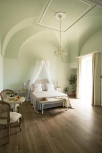 奥斯图尼Biancadamare的卧室配有白色的床和吊灯。