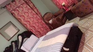 库马西Gya-son Royal Guest House的一间卧室配有一张床和红色枕头