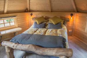GlenfargLittle Lochan Lodge的木质小屋内的一张床位,铺有木地板