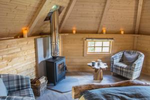 GlenfargLittle Lochan Lodge的小木屋内带炉灶的客厅