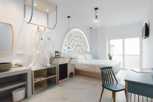 法里拉基Mylos Luxury Escape的一间卧室配有一张床和一张桌子及椅子