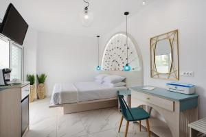 法里拉基Mylos Luxury Escape的一间卧室配有一张床、一张书桌和一面镜子