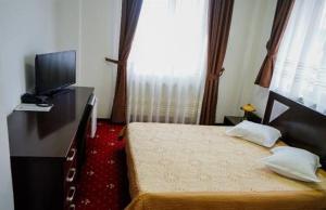 皮特什蒂Hotel Sorelo的一间卧室配有一张床、一台电视和一个梳妆台