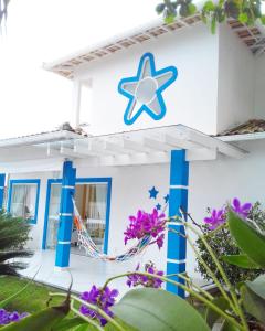 布希奥斯Estrela Azul Guest House Búzios的白色的房子,上面有蓝色的星