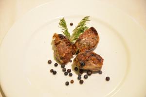 科玛南扎达罗维利诺餐厅酒店的盘子里放有肉和香料的食物