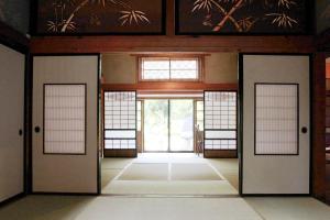 佐渡市carafuru Japanese Old House的建筑中带门窗的空房间