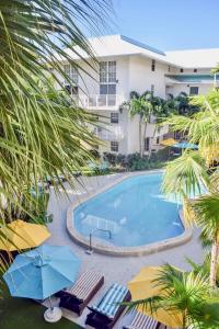 迈阿密Suites at Coral Resorts的享有带椅子和遮阳伞的游泳池的上方景色