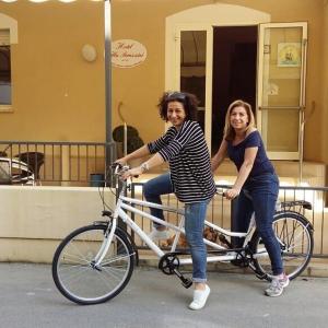 里米尼Hotel Villa Perazzini的两名妇女在街上骑着自行车
